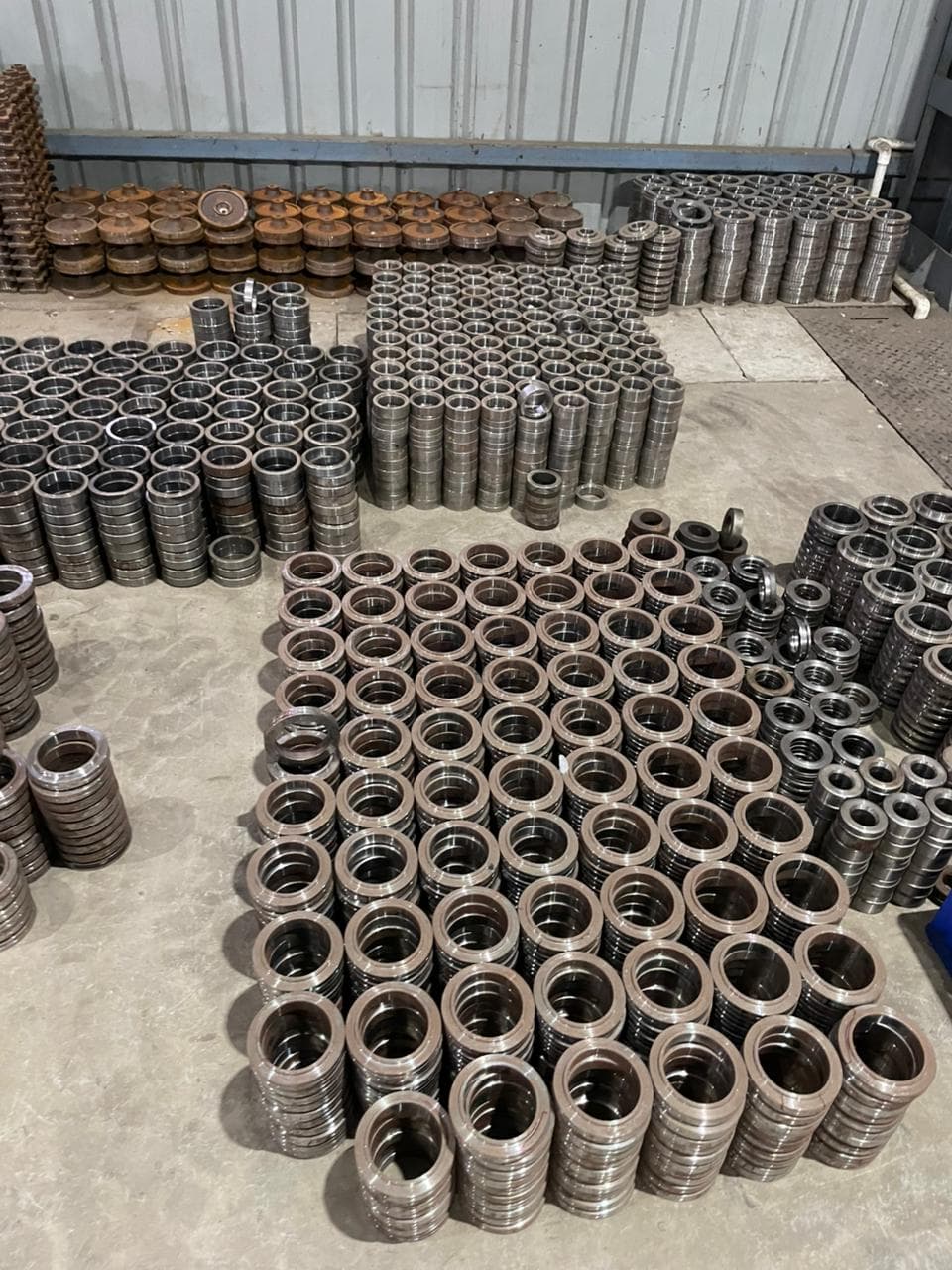 Large-diameter bearing rings placed on inspection stands inside the plant.